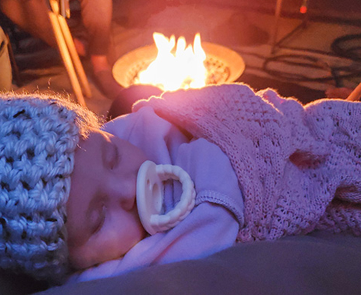 Baby Sleeping Near Fire Pit